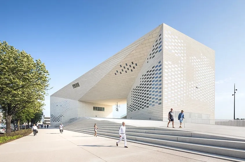 En marches ou gradins, rampes ou plateforme, le socle de la Méca s’apparente à un espace public, singularisé par les panneaux de béton clair qui le couvrent à l’unisson des façades. En marches ou gradins, rampes ou plateforme, le socle de la Méca s’apparente à un espace public, singularisé par les panneaux de béton clair qui le couvrent à l’unisson des façades.