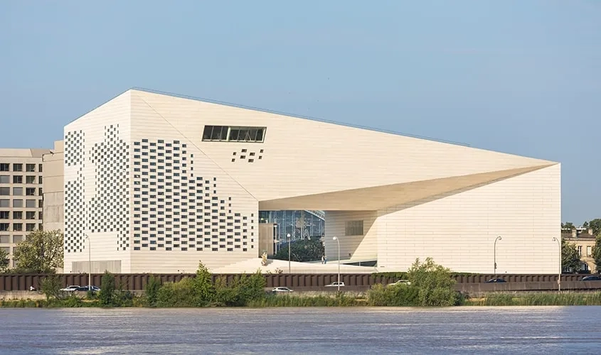 Depuis le fleuve, l’ouverture du volume tempère la massivité du bâtiment. Depuis le fleuve, l’ouverture du volume tempère la massivité du bâtiment.