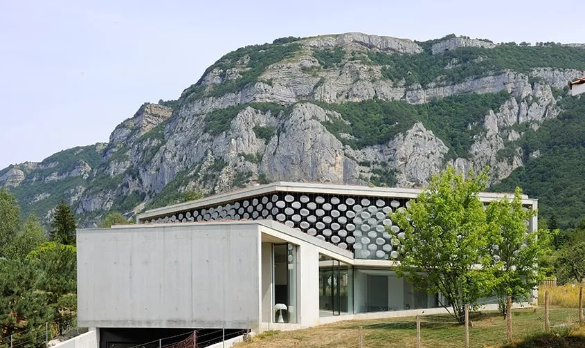 Le volume en étoile à trois branches de la maison s’inscrit dans le paysage dominé par les parois du Salève.