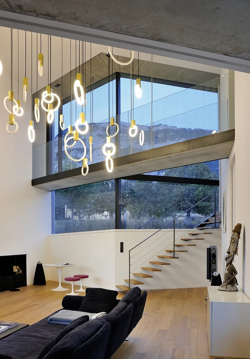 Une passerelle suspendue, qui traverse l’espace double hauteur du salon, relie la chambre parentale au palier d’étage.