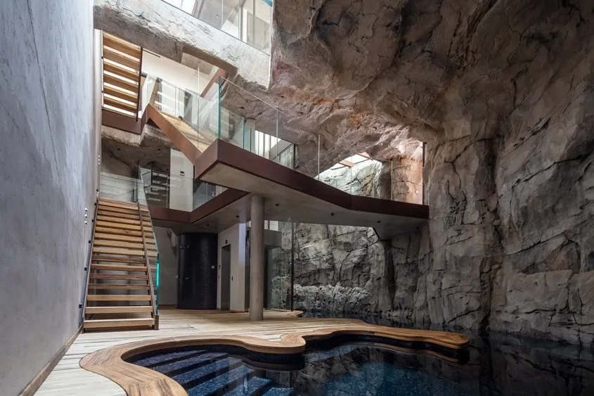 Dès l’entrée, le vide et les planchers transparents offrent des perspectives sur tout l’intérieur de la maison où le béton scénographie l’architecture rocailleuse.