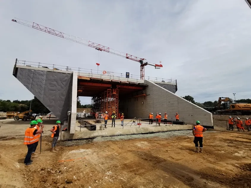 Une fois la brèche créée dans le remblai ferroviaire, le parcours de ripage a été scalpé à la bonne cote, afin de permettre à l’ouvrage de glisser sans effort excessif. Le ripage proprement dit a alors pu se dérouler : huit heures ont été nécessaires pour faire parcourir au pont-rail de quelque 6 500 tonnes les 49 mètres qui le séparaient de son emplacement définitif.