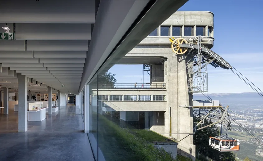 Raccordée au bâtiment-pont, la salle d’exposition s’intègre au paysage.