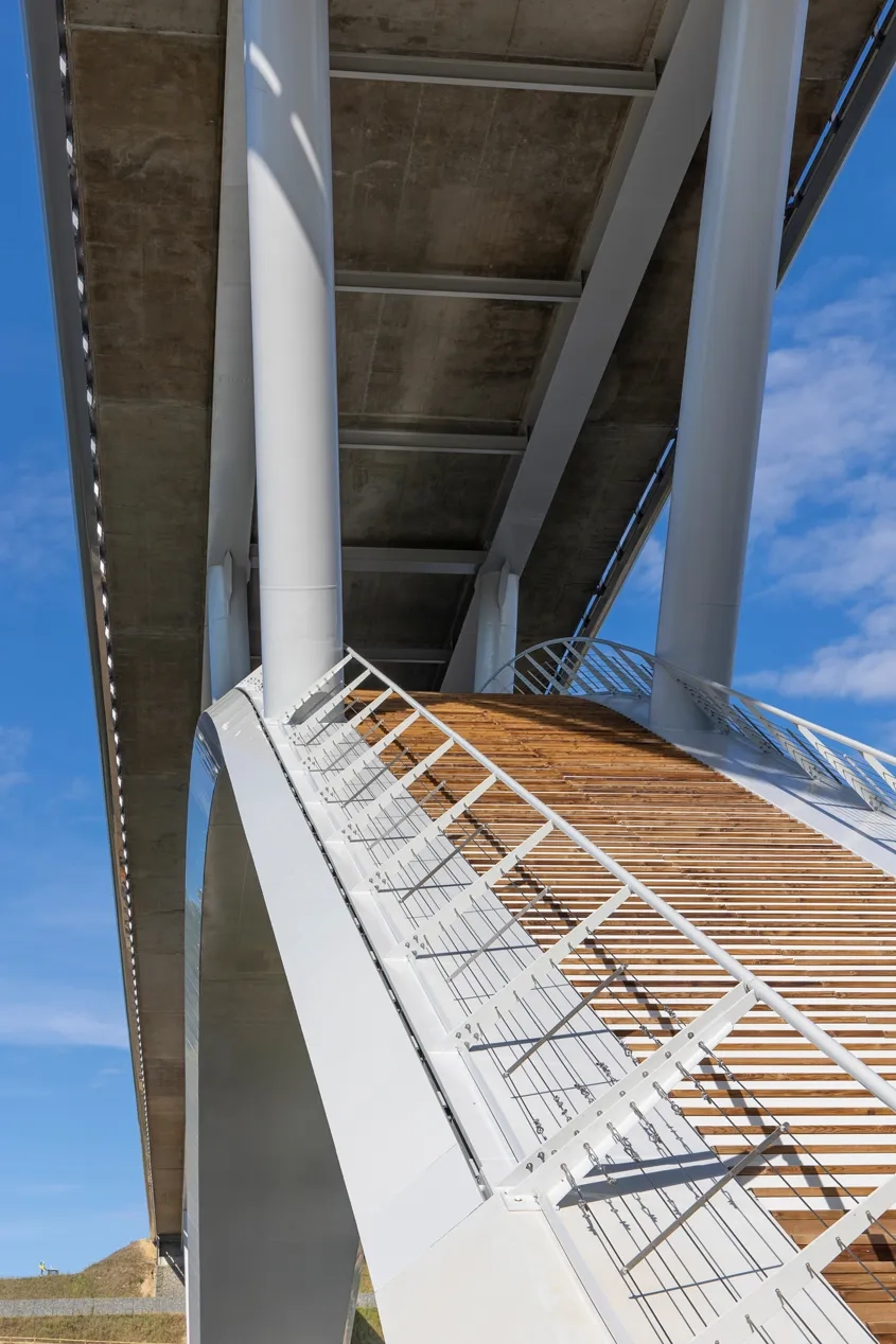 L’extrados de l’arc est utilisé comme une passerelle piétonne. 140 marches en bois de largeur variable sont positionnées sur chacune des pentes de l’arc et donnent accès à une plateforme belvédère située à la clé, à 25 mètres au-dessus de la Mayenne. © Xavier BOYMOND