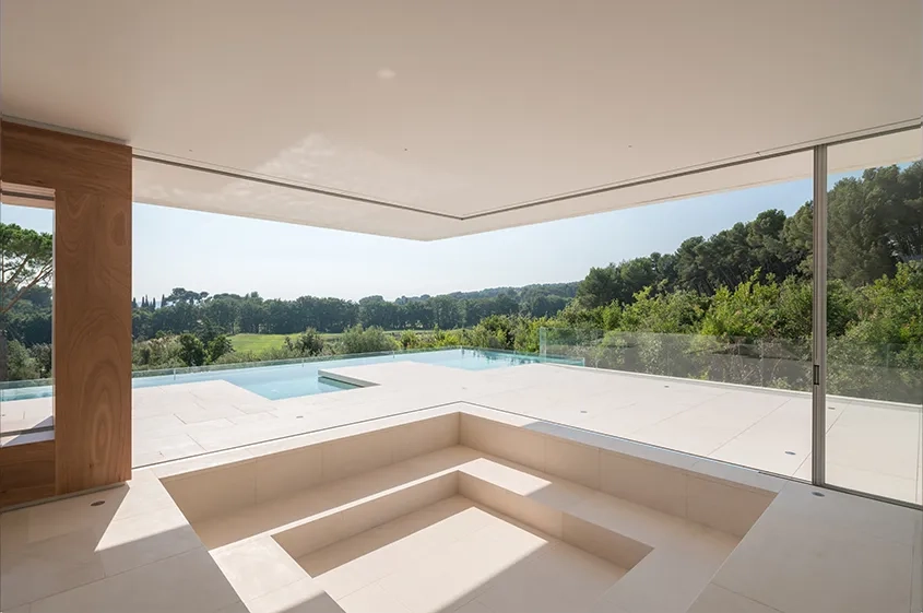 Villa SI – Dans le séjour, le grand porte-à-faux du plafond oriente et cadre les vues sur le paysage. Villa SI – Dans le séjour, le grand porte-à-faux du plafond oriente et cadre les vues sur le paysage.