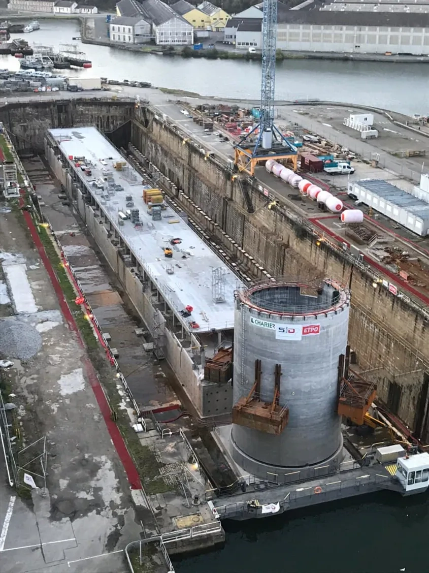 Le ponton (160 m de long, 17 m de large et 9 m de hauteur) et le musoir (23 m de haut et 14 m de diamètre) ont été construits au sec dans le bassin n° 4 de la base navale de Brest, mis à disposition par le maître d’ouvrage. Les dimensions de cette forme de radoub étaient suffisantes pour pouvoir ériger simultanément les deux ouvrages. Le ponton (160 m de long, 17 m de large et 9 m de hauteur) et le musoir (23 m de haut et 14 m de diamètre) ont été construits au sec dans le bassin n° 4 de la base navale de Brest, mis à disposition par le maître d’ouvrage. Les dimensions de cette forme de radoub étaient suffisantes pour pouvoir ériger simultanément les deux ouvrages.