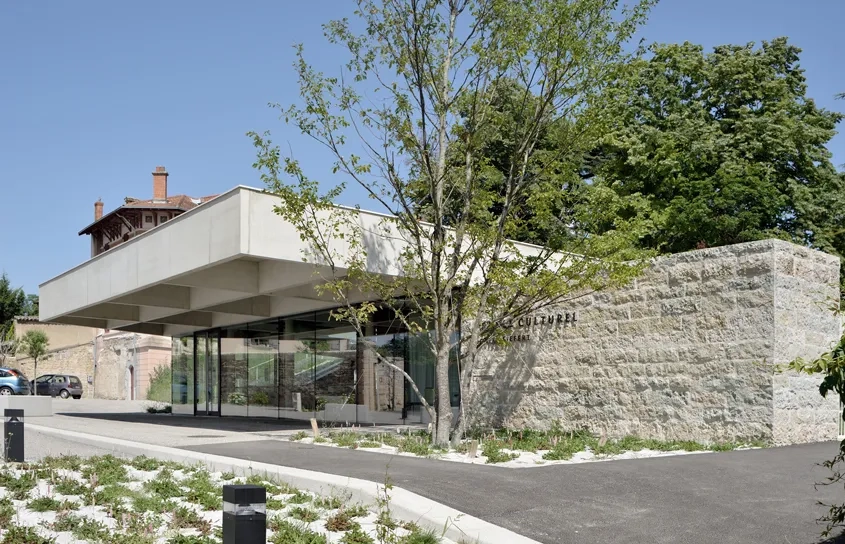 La toiture qui s’avance par un généreux porte-à-faux sur le parvis invite à entrer dans la bibliothèque, dont on découvre tout l’intérieur à travers la façade entièrement vitrée. La toiture qui s’avance par un généreux porte-à-faux sur le parvis invite à entrer dans la bibliothèque, dont on découvre tout l’intérieur à travers la façade entièrement vitrée.