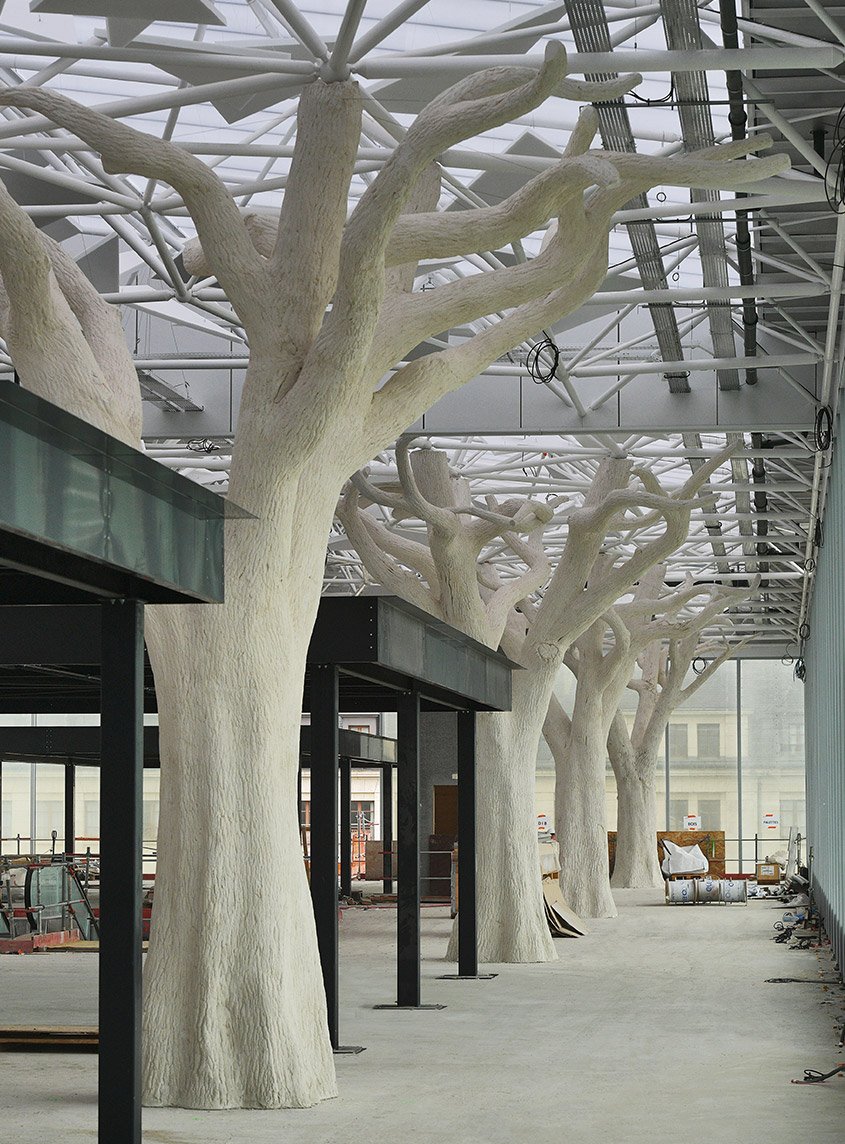À 10 m du sol, la couverture de la mezzanine est portée par une allée d’arbres en béton projeté.