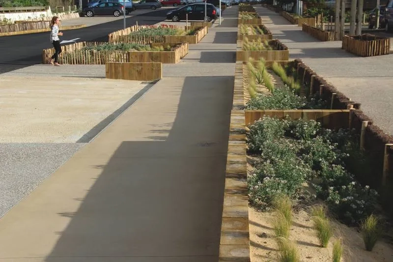 Les trottoirs en béton de sable, agrémentés de jardinières. Les trottoirs en béton de sable, agrémentés de jardinières.
