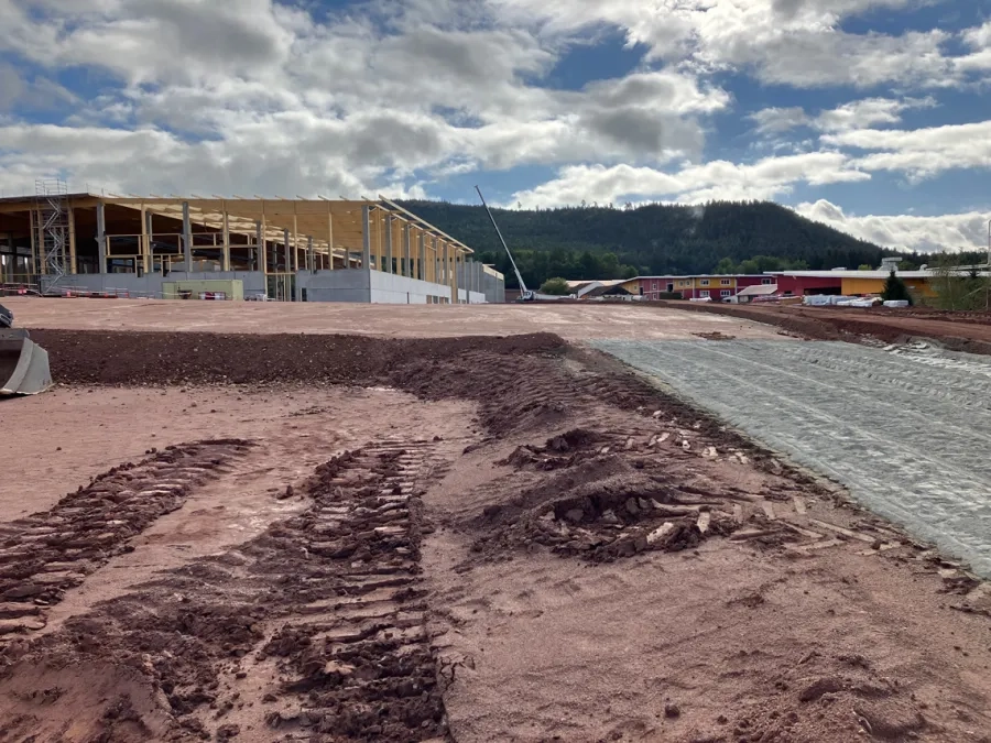 Vue générale du projet d’extension, avec au premier plan la plate-forme des aménagements extérieurs en cours de traitement au liant LV-TS 54. (© Scierie-Gaiffe et Avinim Construction)