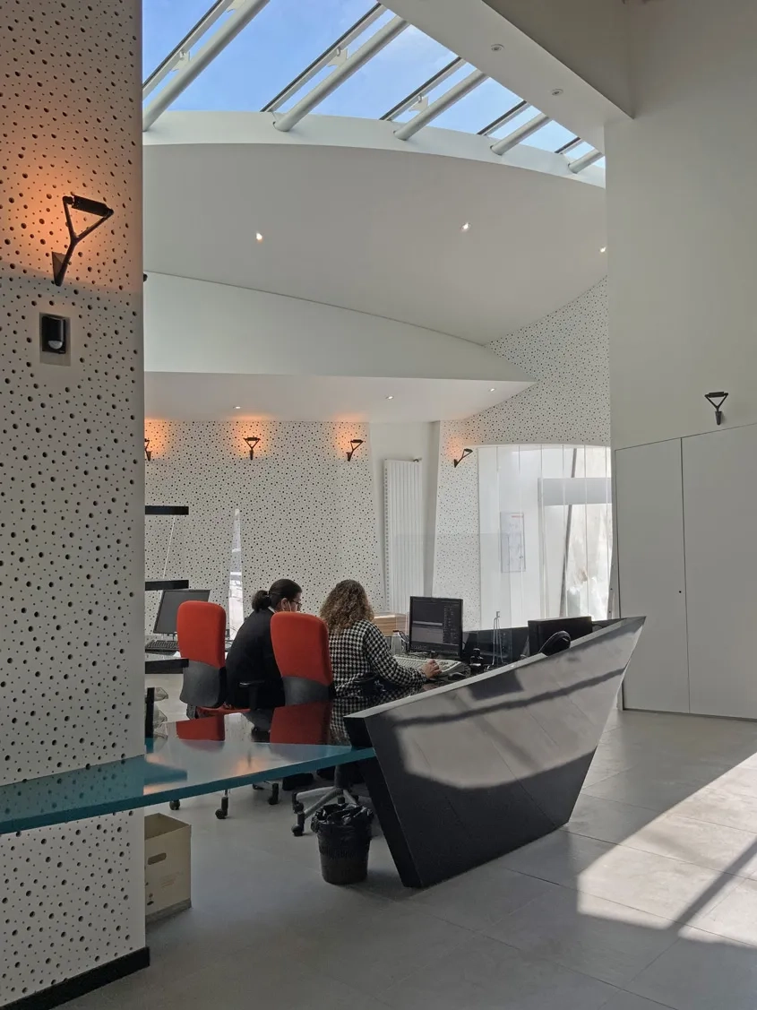 Une verrière apporte la lumière naturelle au-dessus de la banque d’accueil, dont elle souligne la présence, tout en mettant en valeur l’espace du hall.