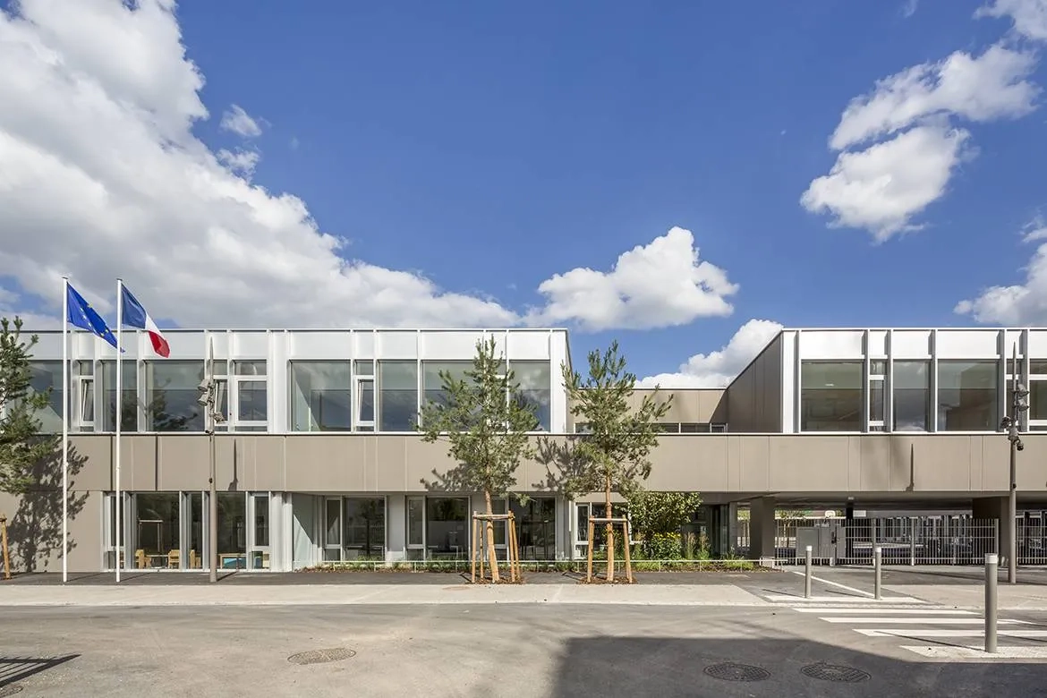 Vue sur l’école élémentaire, dont le préau se glisse sous le bâtiment pour signaler l’entrée  et ouvrir  la cour sur  la promenade.
