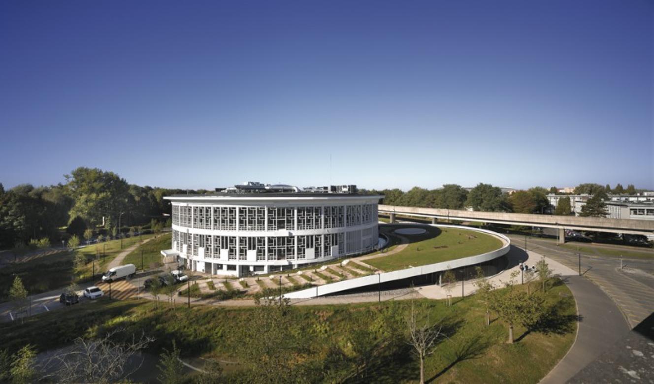 La toiture végétalisée de l’extension, directement accessible depuis le sol, devient une prolongation des espaces verts du campus.